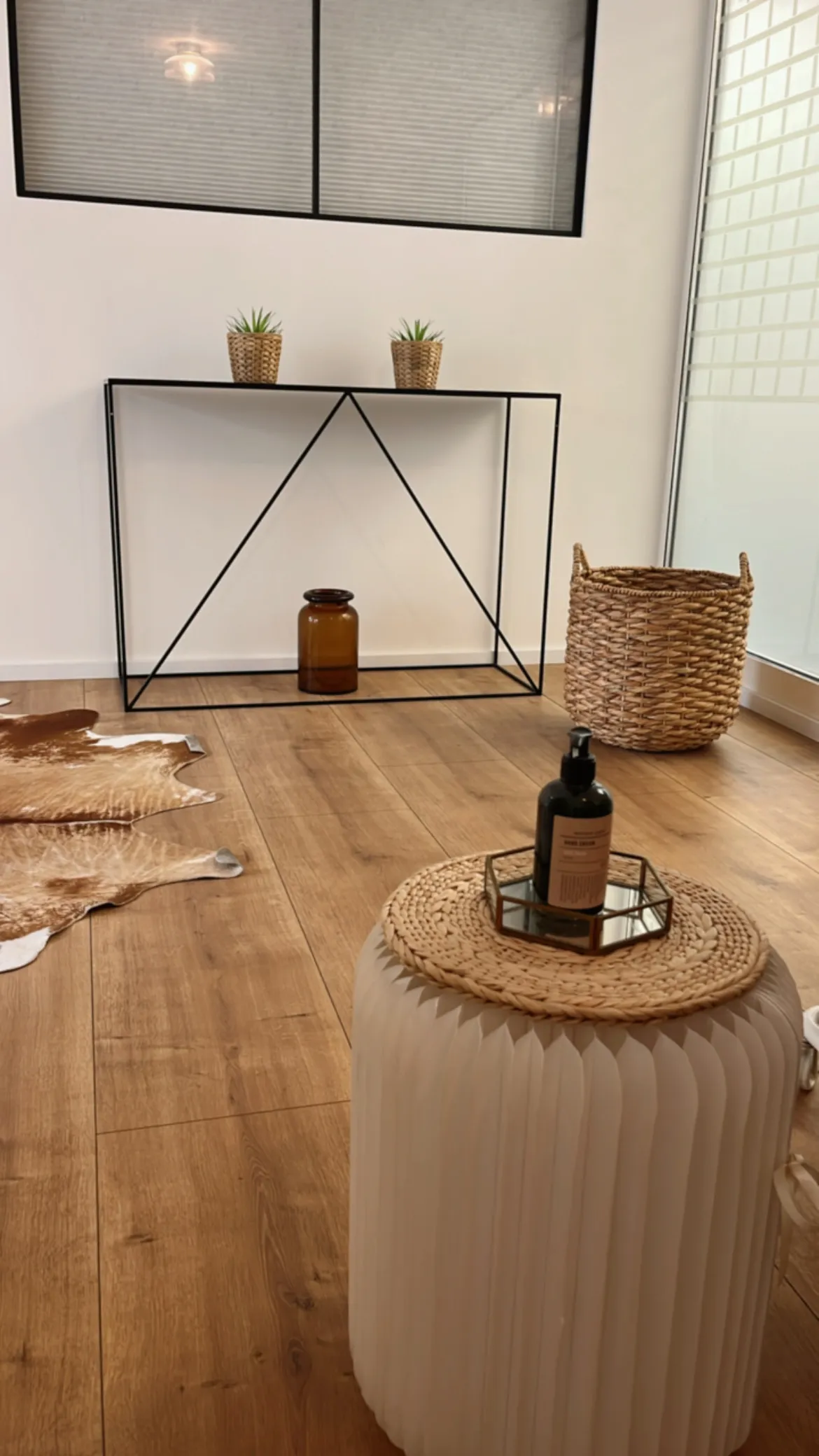 L'espace de l'institut : parquet clair, mobilier fin en métal noir et paniers en osier